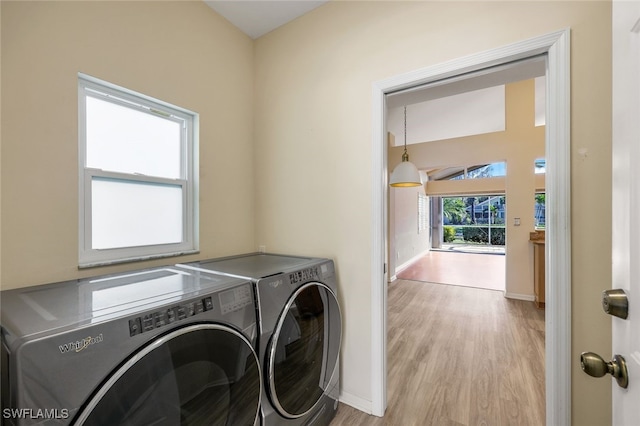 clothes washing area featuring washer and clothes dryer and light hardwood / wood-style floors