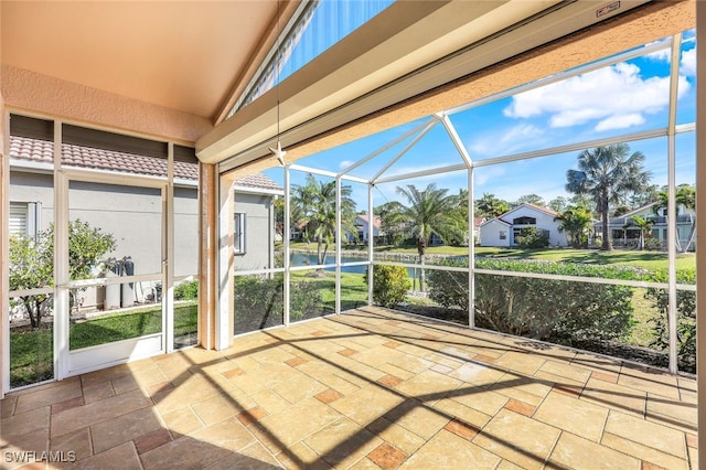 unfurnished sunroom featuring a water view and vaulted ceiling