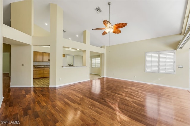 unfurnished living room with ceiling fan, wood-type flooring, and high vaulted ceiling