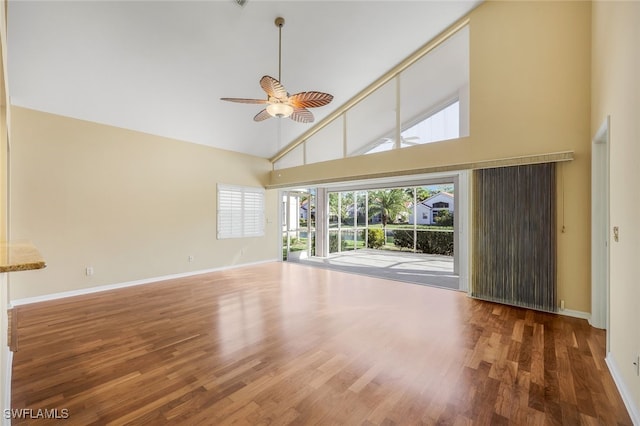 unfurnished living room with hardwood / wood-style flooring, ceiling fan, and high vaulted ceiling