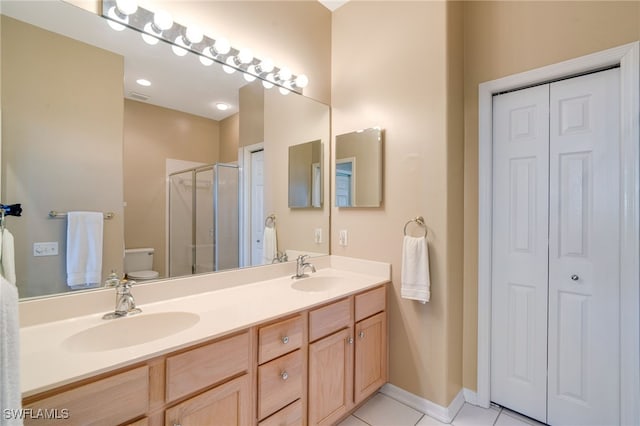 bathroom with tile patterned flooring, vanity, toilet, and an enclosed shower