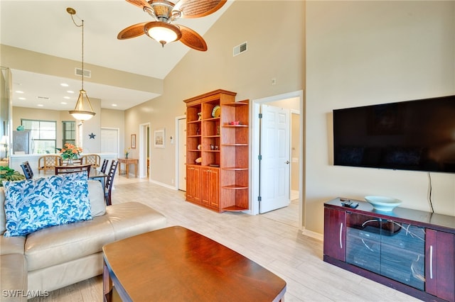 living room with ceiling fan, light hardwood / wood-style flooring, and high vaulted ceiling