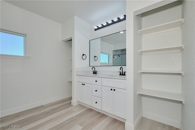 bathroom with wood-type flooring, vanity, and walk in shower