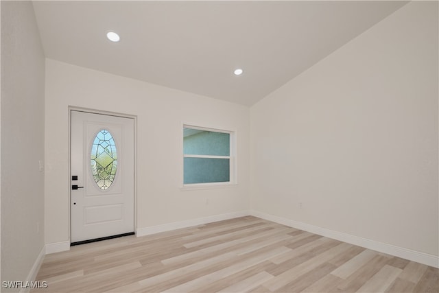 foyer with light wood-type flooring and vaulted ceiling