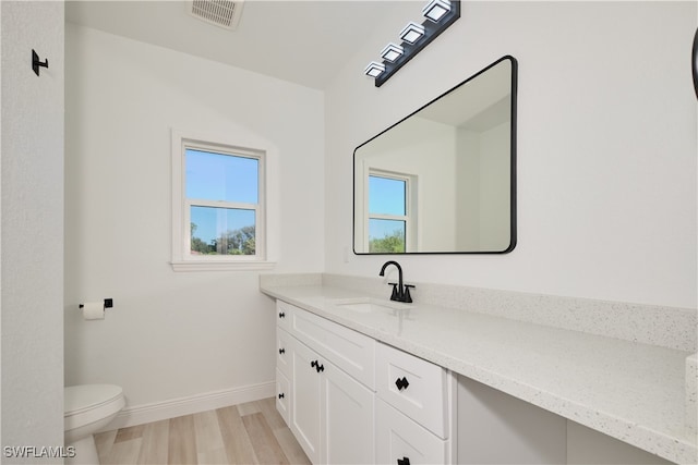 bathroom featuring hardwood / wood-style floors, vanity, and toilet