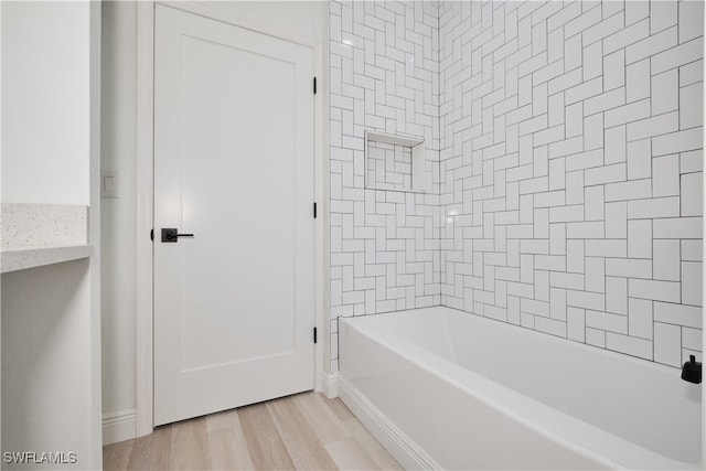 bathroom featuring tiled shower / bath combo and wood-type flooring