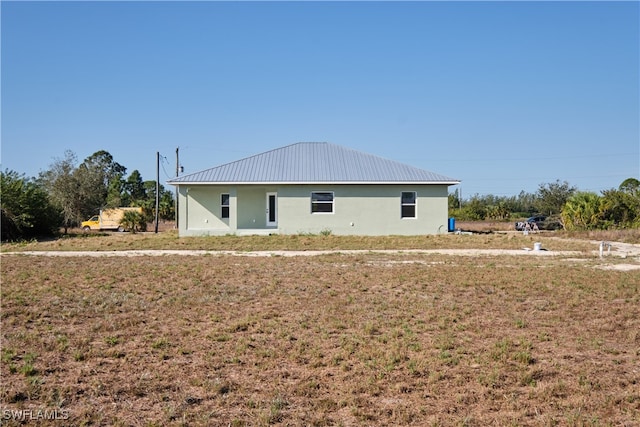rear view of house featuring a yard