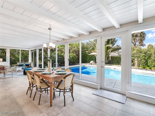 sunroom with beamed ceiling, french doors, and an inviting chandelier