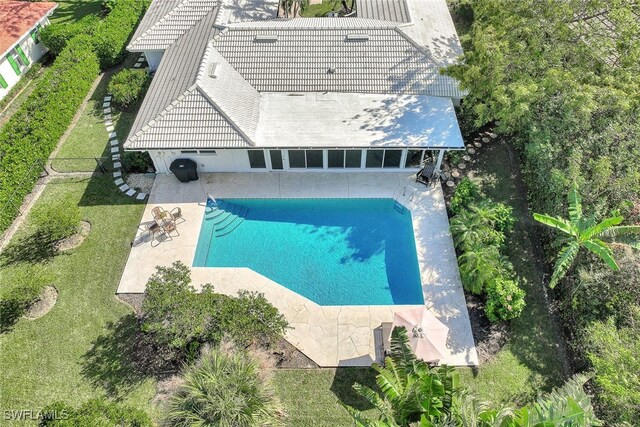 view of pool featuring a lawn and a patio