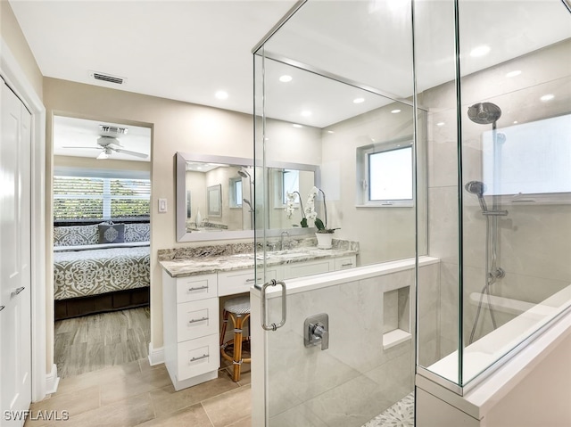 bathroom with ceiling fan, a shower with door, and vanity