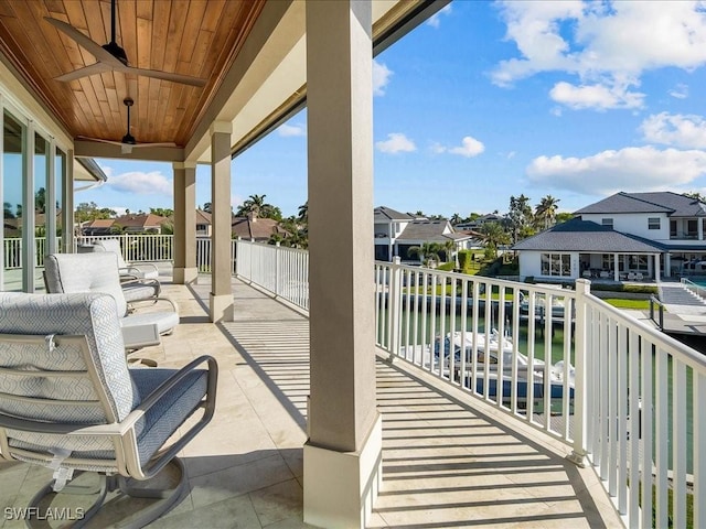 view of patio featuring ceiling fan, a balcony, and a water view