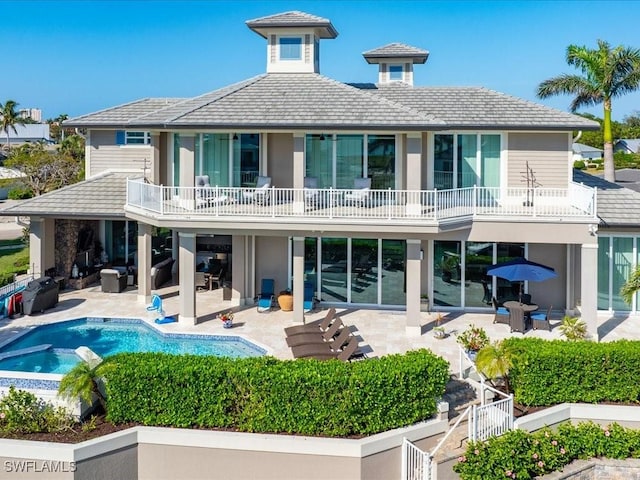 rear view of house featuring a fenced in pool, a patio area, and a balcony