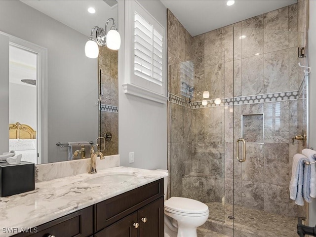 bathroom featuring toilet, vanity, and walk in shower