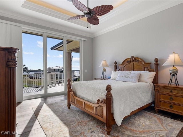 bedroom featuring access to exterior, a tray ceiling, ceiling fan, and ornamental molding