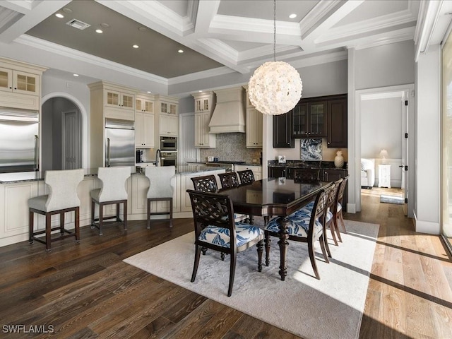 dining room with coffered ceiling, beamed ceiling, dark hardwood / wood-style floors, a chandelier, and ornamental molding