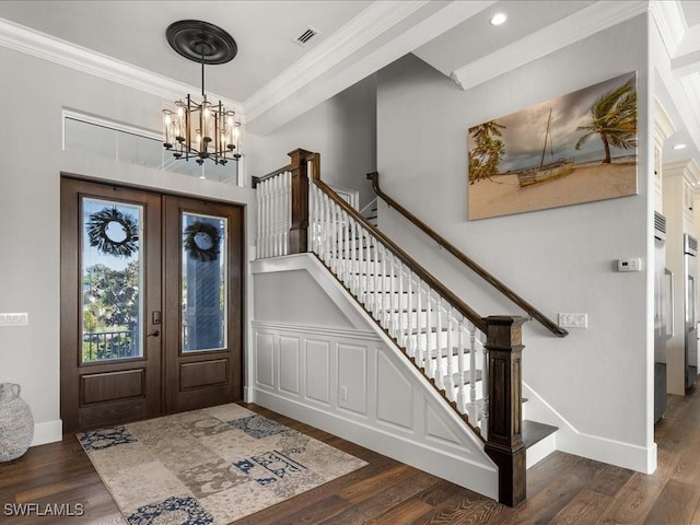 foyer entrance with a chandelier, ornamental molding, dark wood-type flooring, and french doors