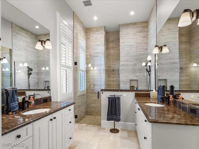 bathroom with vanity, walk in shower, and tile walls