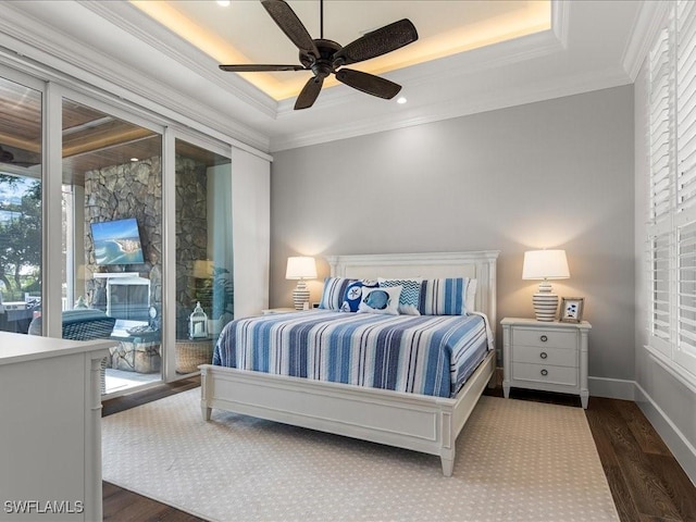 bedroom with a raised ceiling, access to exterior, ceiling fan, and dark wood-type flooring