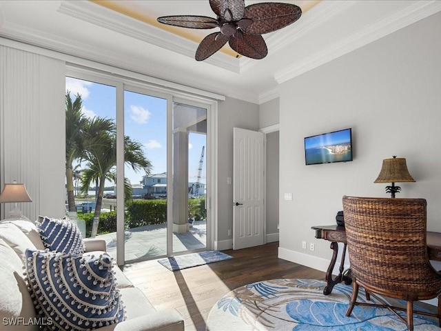 interior space with ceiling fan, dark hardwood / wood-style flooring, ornamental molding, and a tray ceiling