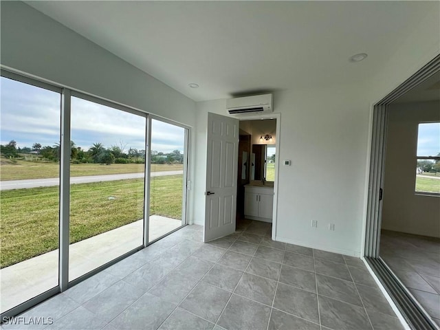 interior space with ensuite bathroom, light tile patterned floors, and a wall mounted air conditioner