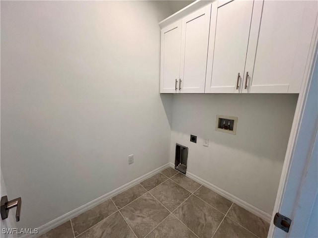 washroom with hookup for a washing machine, cabinets, dark tile patterned flooring, and hookup for an electric dryer