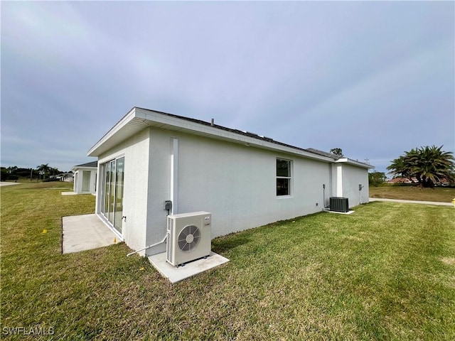 view of home's exterior with a lawn, ac unit, and cooling unit