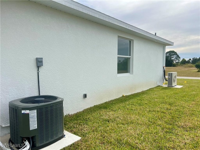 view of home's exterior with a yard, cooling unit, and ac unit