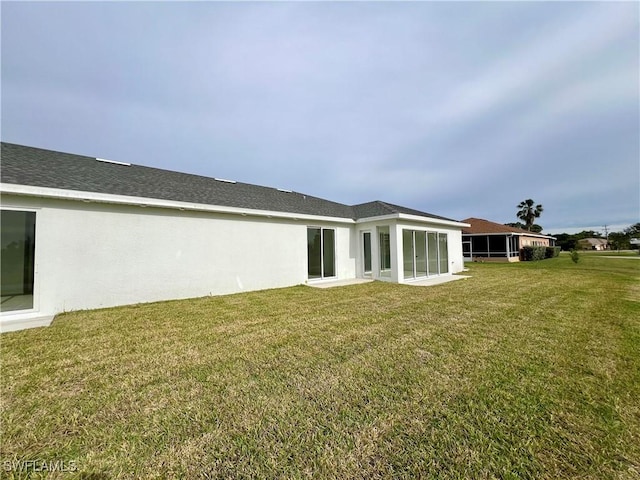 rear view of house featuring a sunroom and a yard