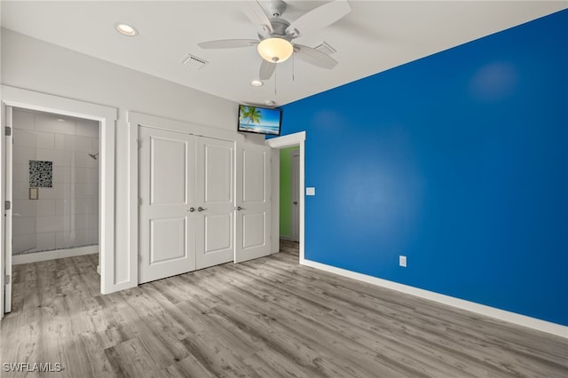 unfurnished bedroom featuring ceiling fan, light wood-style flooring, visible vents, baseboards, and a closet