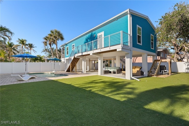 rear view of property featuring a fenced in pool, a patio, outdoor lounge area, stairway, and fence