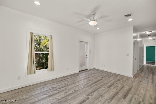 empty room with baseboards, light wood finished floors, visible vents, and recessed lighting