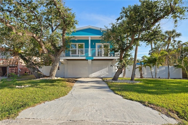 coastal home featuring a front lawn and fence