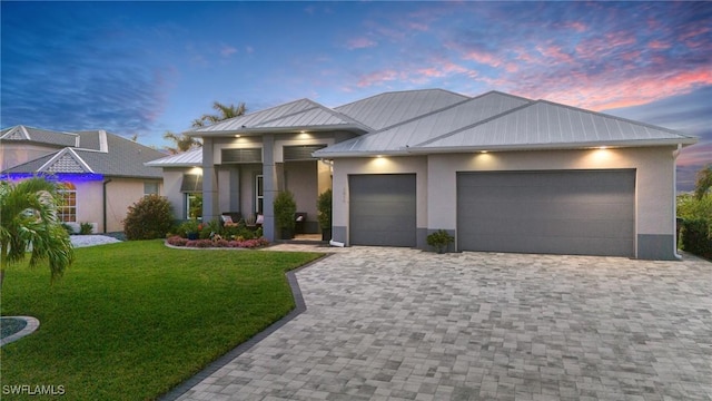 view of front of house featuring a garage and a lawn