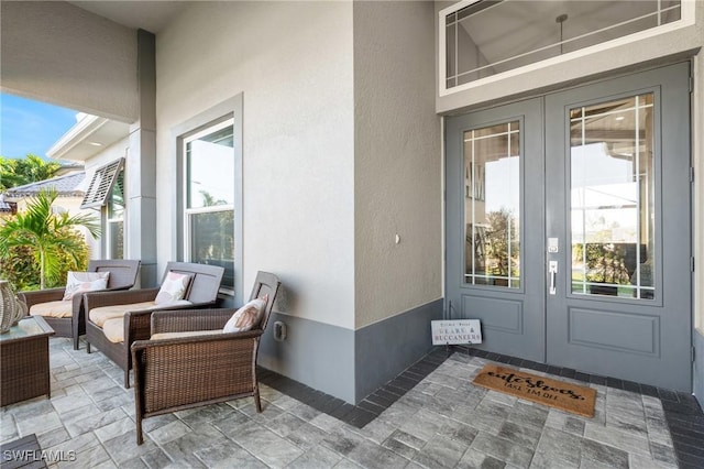 doorway to property featuring outdoor lounge area, french doors, and a patio area