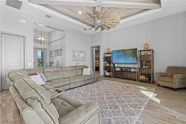 living room featuring ceiling fan with notable chandelier, light hardwood / wood-style floors, and wood ceiling