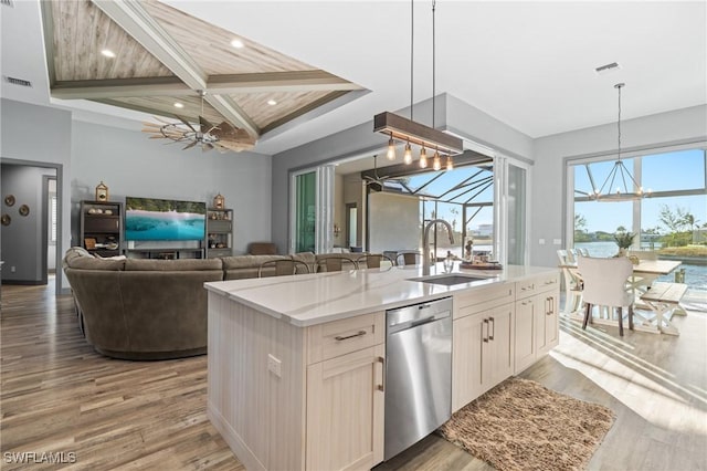 kitchen featuring coffered ceiling, sink, beamed ceiling, dishwasher, and an island with sink