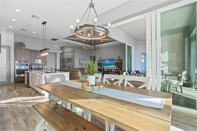 dining area with sink, a chandelier, and hardwood / wood-style flooring