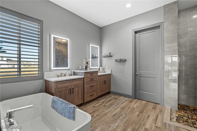 bathroom featuring separate shower and tub, vanity, and wood-type flooring