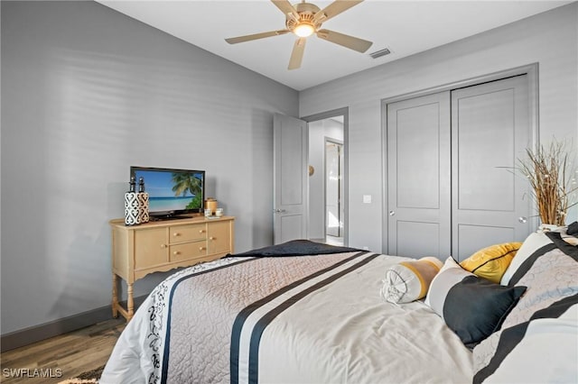 bedroom with hardwood / wood-style floors, a closet, and ceiling fan