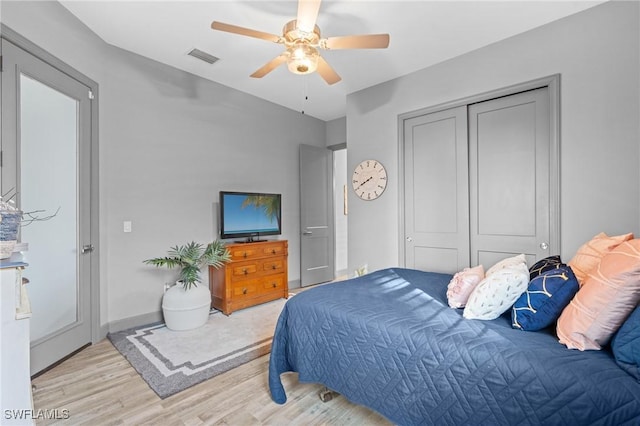 bedroom featuring light wood-type flooring, a closet, and ceiling fan