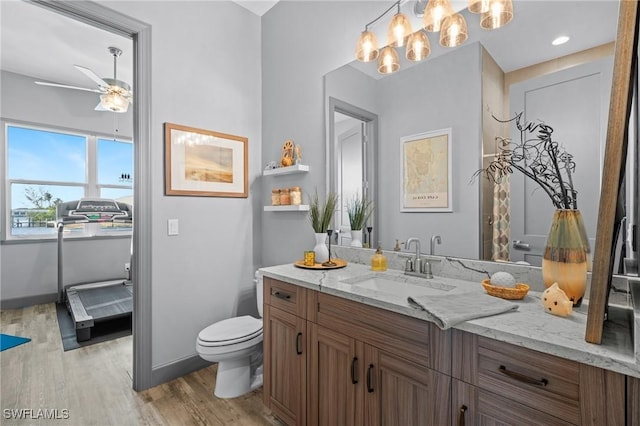 bathroom featuring ceiling fan, vanity, wood-type flooring, and toilet