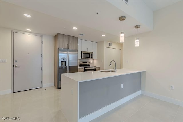26610 Rosewood Pointe Dr Unit 308, Bonita Springs, FL 34135 - kitchen featuring appliances with stainless steel finishes, kitchen peninsula, light tile patterned floors, sink, and decorative light fixtures