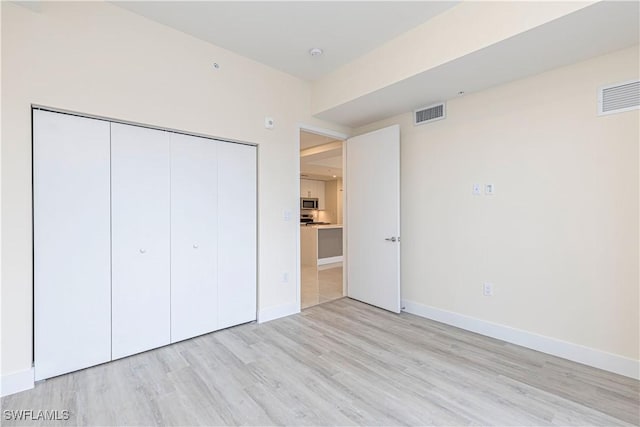 26610 Rosewood Pointe Dr Unit 308, Bonita Springs, FL 34135 - unfurnished bedroom featuring light wood-type flooring and a closet