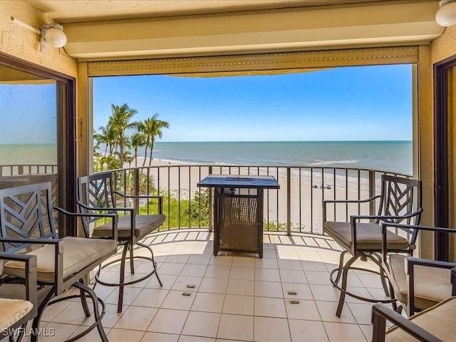 balcony featuring a water view and a beach view