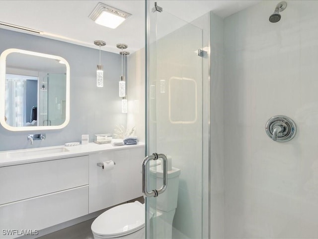 bathroom featuring walk in shower, vanity, and toilet