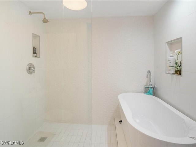 bathroom featuring shower with separate bathtub