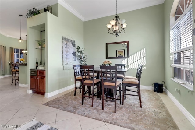 tiled dining space featuring a chandelier and ornamental molding