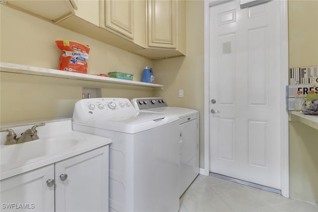 washroom with washer and clothes dryer, light tile patterned flooring, cabinets, and sink