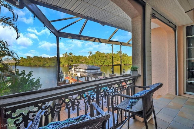 balcony with a water view and a dock