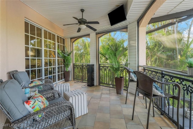 sunroom featuring ceiling fan